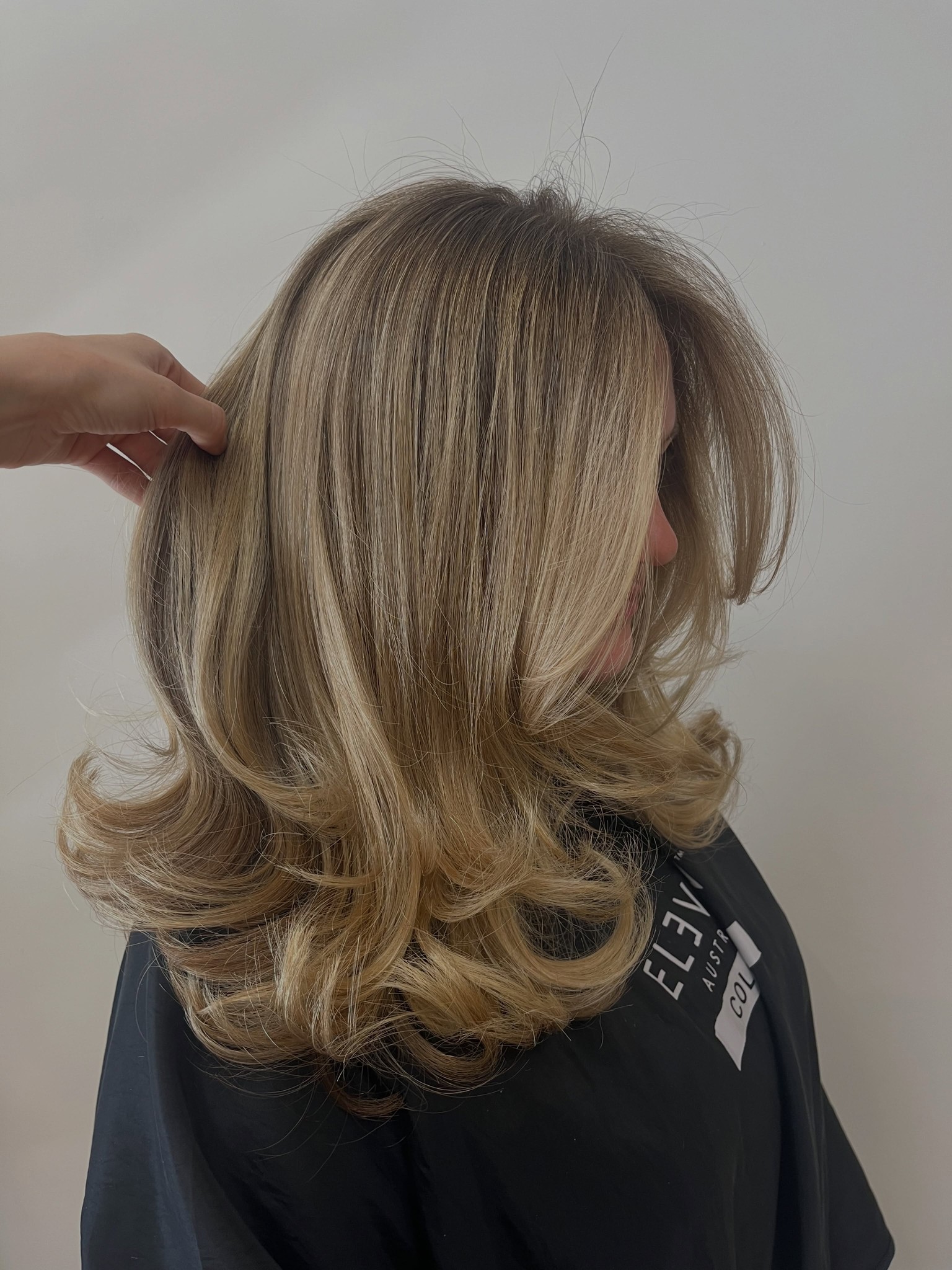 Blond haar op schouderlengte met naar buiten gekrulde punten