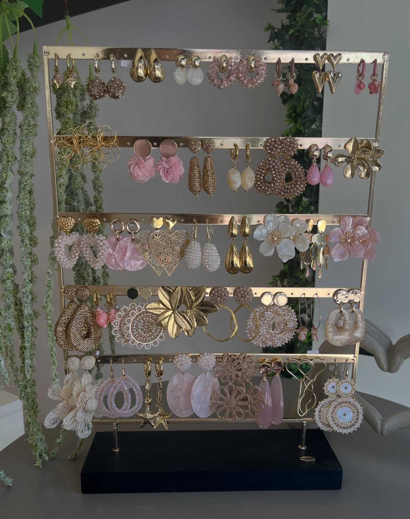 Rek met oorbellen in goud, roze en parelmoer